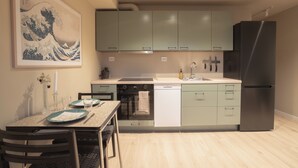 Una cocina moderna con armarios verde claro, un refrigerador negro y una mesa de comedor con platos y cubiertos.