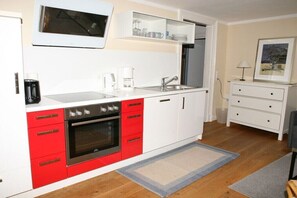 Eine kleine Küche mit Backofen, Kaffeemaschine und Spüle.