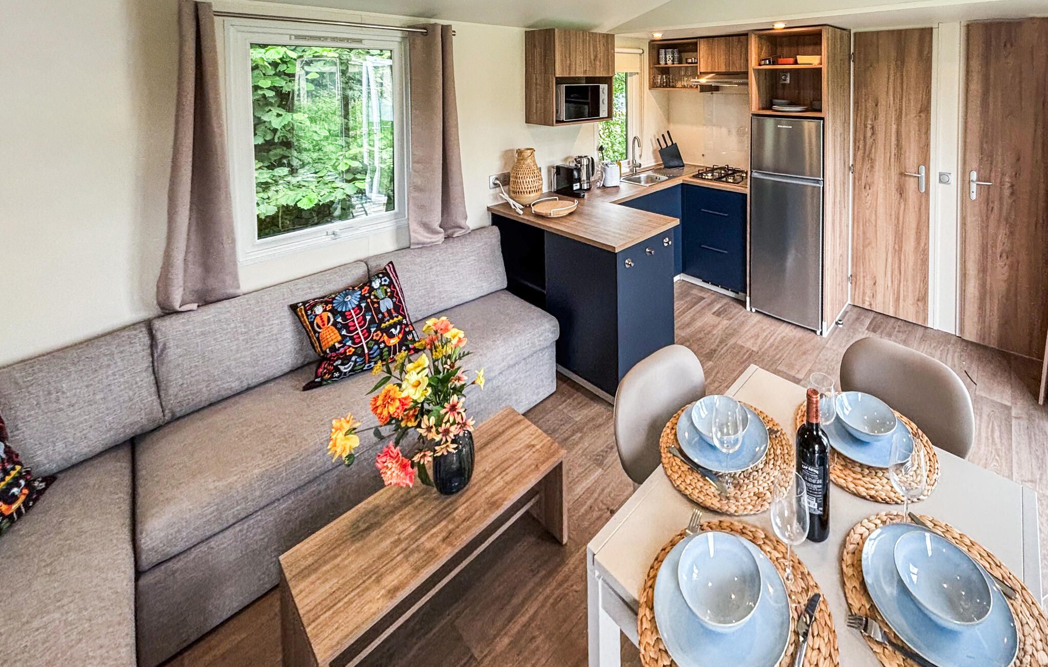 Une petite cuisine équipée d’un four à micro-ondes, d’une cuisinière et d’un réfrigérateur.