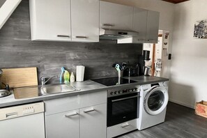 A modern kitchen with a built-in oven, a washing machine, and a dishwasher. - Holiday apartment with 1 bedroom (Bremen)