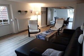 A modern living room with a sofa, two chairs, a coffee table, and a lamp. - Wattenhuus Förrien 2a (Minsen - Förrien)