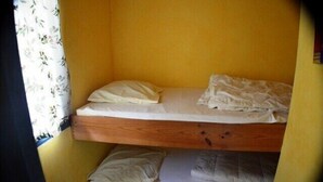 A bunk bed with two levels, each with a pillow and a blanket. - Cabin #13, sleeps 4, Domaine de Ribière (Grospierres)
