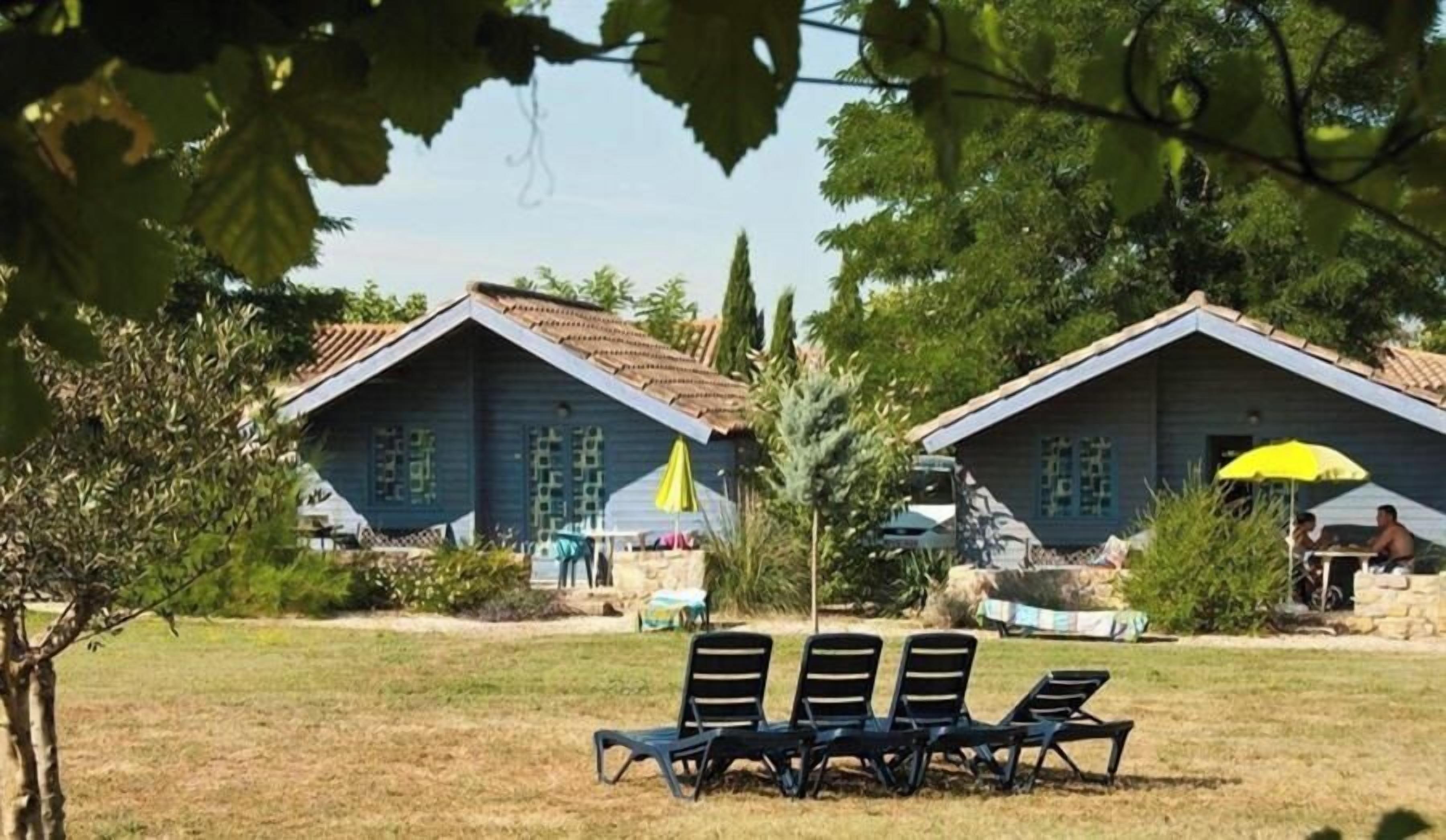A property with two buildings, outdoor seating, and a clear sky.