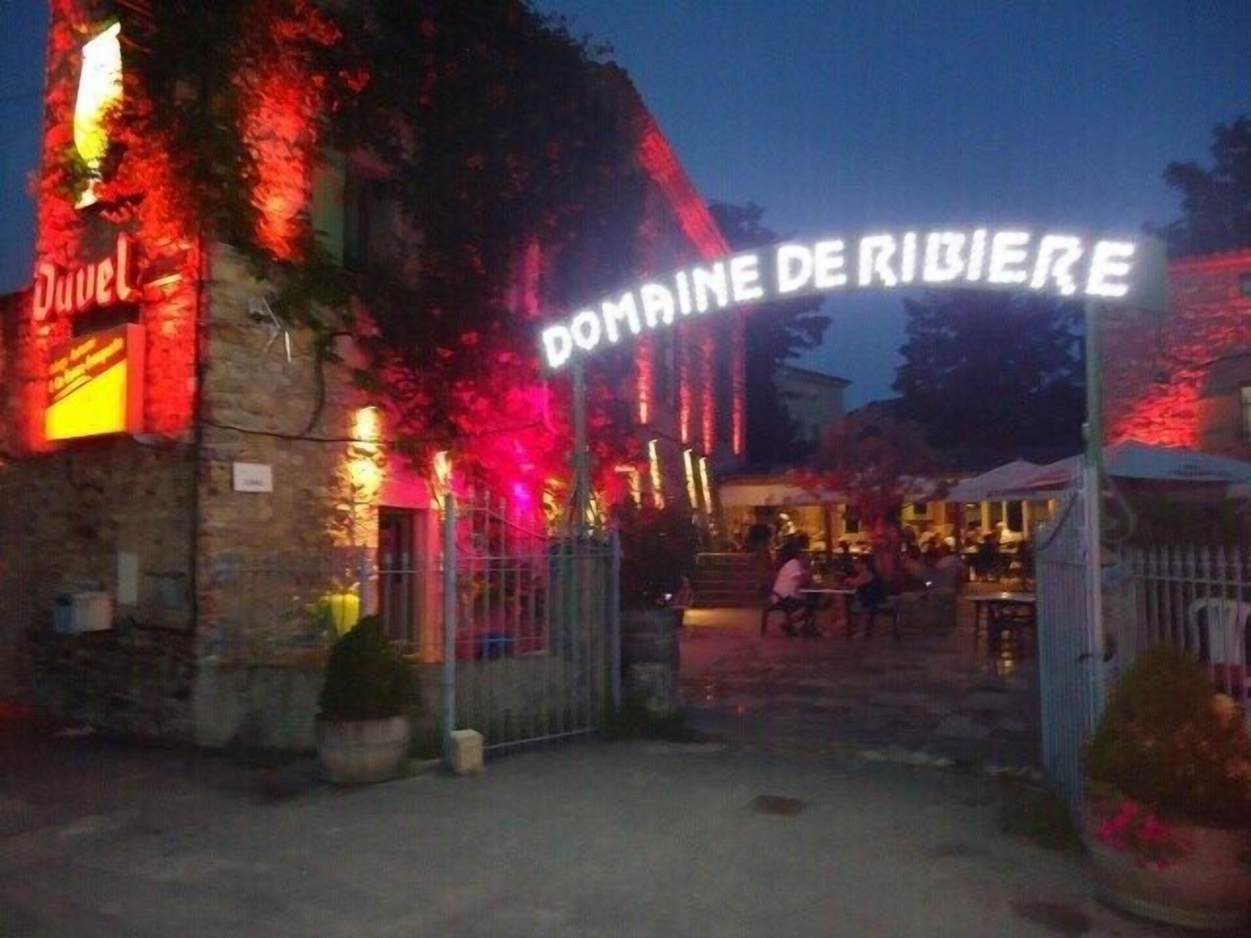 A building with a sign that reads 'DOMAINE DE RIBIERE' and a visible entrance gate.