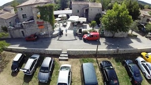 A parking area with multiple cars and a building with a sign. - Vrbo Property (Grospierres)