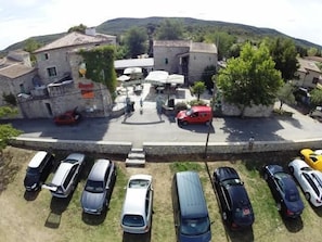 Um estacionamento com vários carros e um edifício com uma placa que diz 'Ristorante'.