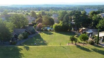 A residential area with houses, a grassy field, and trees.