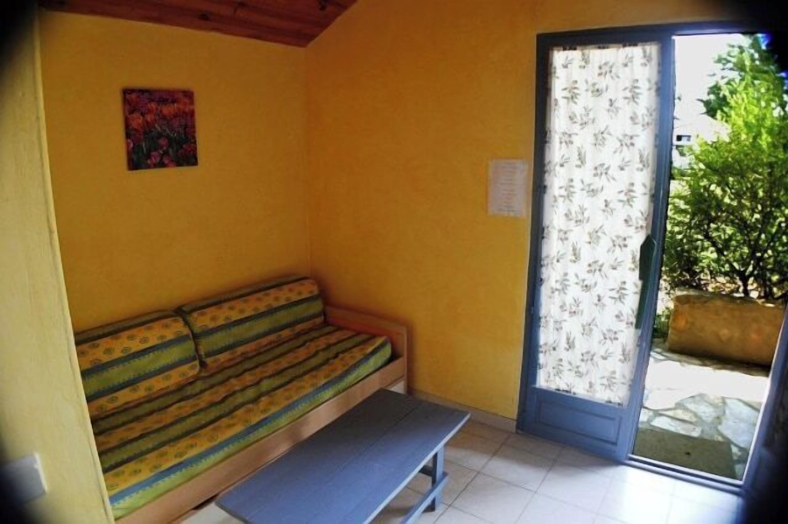 A room with a bench, a sofa, and a door leading outside.