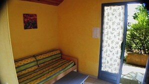 Ein Zimmer mit einer Bank, einem Sofa und einer Tür, die nach draußen führt.