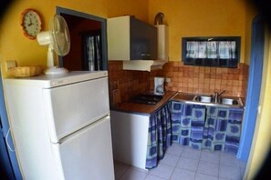 A compact kitchen with a refrigerator, stove, sink, and a fan. - Chalet #14, Sleeps 4, Domaine de Ribière (Grospierres)