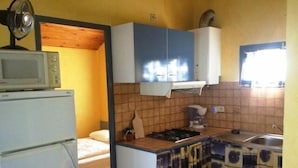 A compact kitchen with a microwave, stove, and sink. - Chalet #15, sleeps 4, Domaine de Ribière (Grospierres)
