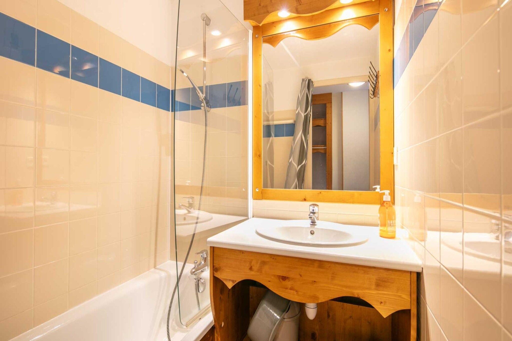 Une salle de bain équipée d’une baignoire, d’un lavabo, d’un miroir et d’un espace douche.