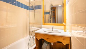 A bathroom with a bathtub, a sink, a mirror, and a shower enclosure. - Alpine Ski Apartment in Tignes for 4 (Chamrousse)