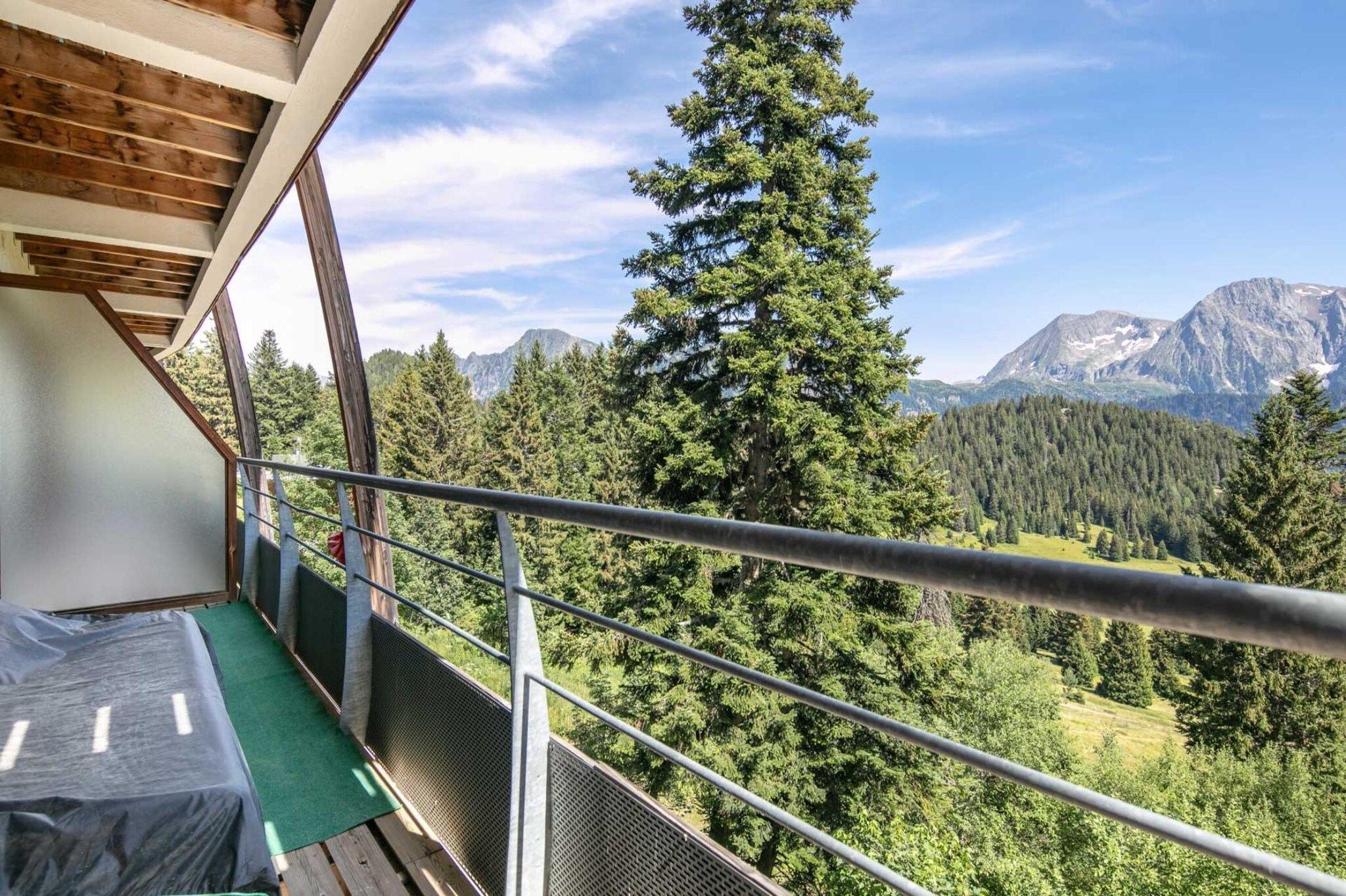 A balcony with a view of a forest and mountains.