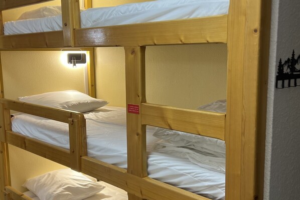 A bunk bed room with a single bed on the top bunk and a wall-mounted light fixture. - Alpine Ski Apartment in Tignes for 4 (Orcières)