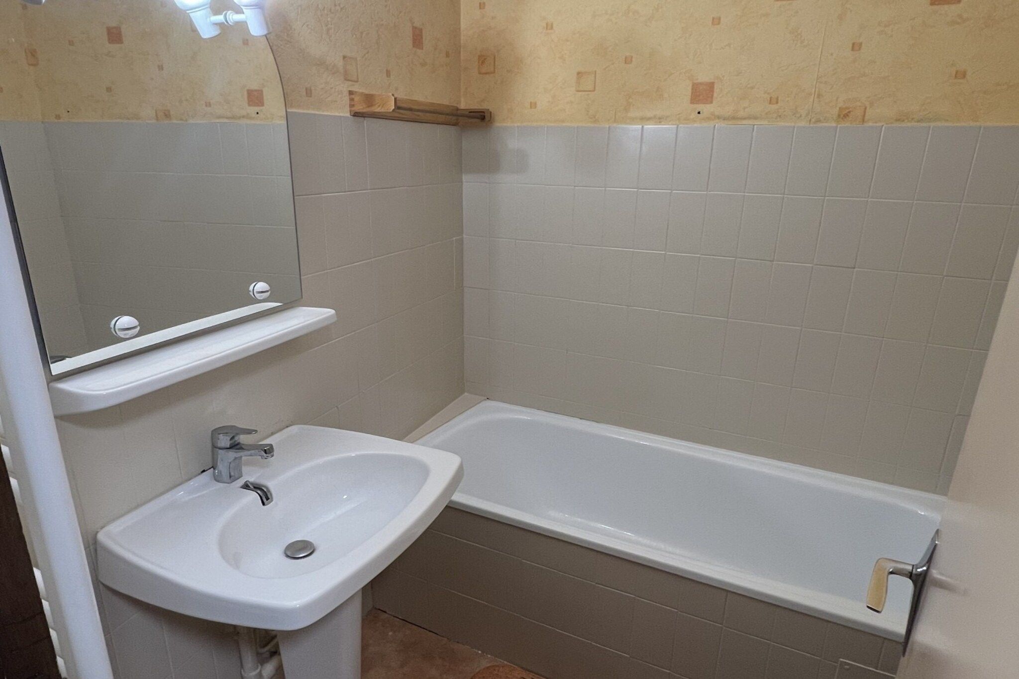 A bathroom with a white sink, a mirror, and a bathtub.