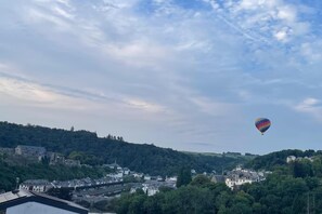 Un globus aerostàtic al cel sobre una vila amb edificis i vegetació.