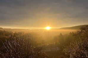 A sunrise over a hilly landscape with a house in the foreground. - Charming Couple Getaway in Bouillon (Bouillon)