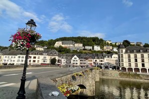 A riverside town with historic buildings, a stone bridge, and a lamppost with flowers. - Charming Couple Getaway in Bouillon (Bouillon)