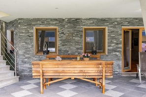 A bathroom with a wooden bench, two windows, and a stone wall. - Chalet in Stuhlfelden near Ski Slopes (Stuhlfelden)