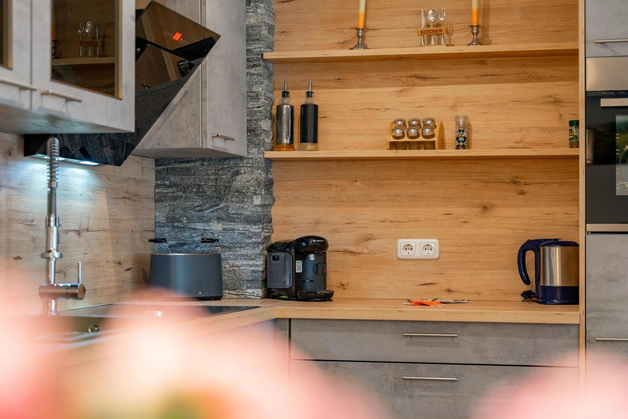 Eine moderne Küche mit Holzböden, einer Kaffeemaschine und einem Wasserkocher.