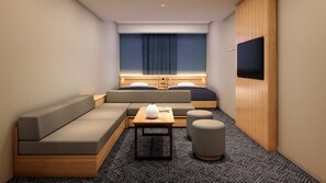 A compact hotel room with a sofa, a small table, a vase, and a TV mounted on the wall. - Minn Ryogoku (Sumida)