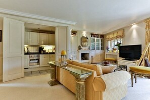 A living room with a sofa, a glass coffee table, and a television. - Holiday home Dünensand (Kampen)