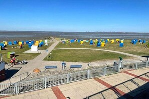 Une plage avec des cabanes colorées et un ciel dégagé.