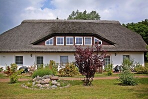 A traditional thatched-roof house with a garden in front. - Kiekenbusch Oben West (Groß Zicker)
