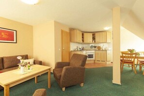 A compact living space with a kitchenette, a dining area, and a seating area. - Kiekenbusch Oben West (Groß Zicker)