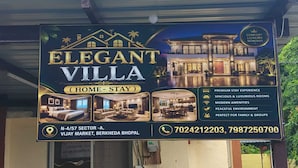 Une enseigne pour « Elegant Villa », mettant en valeur une expérience d’hébergement de qualité supérieure, des chambres spacieuses, des équipements modernes et un environnement paisible.
