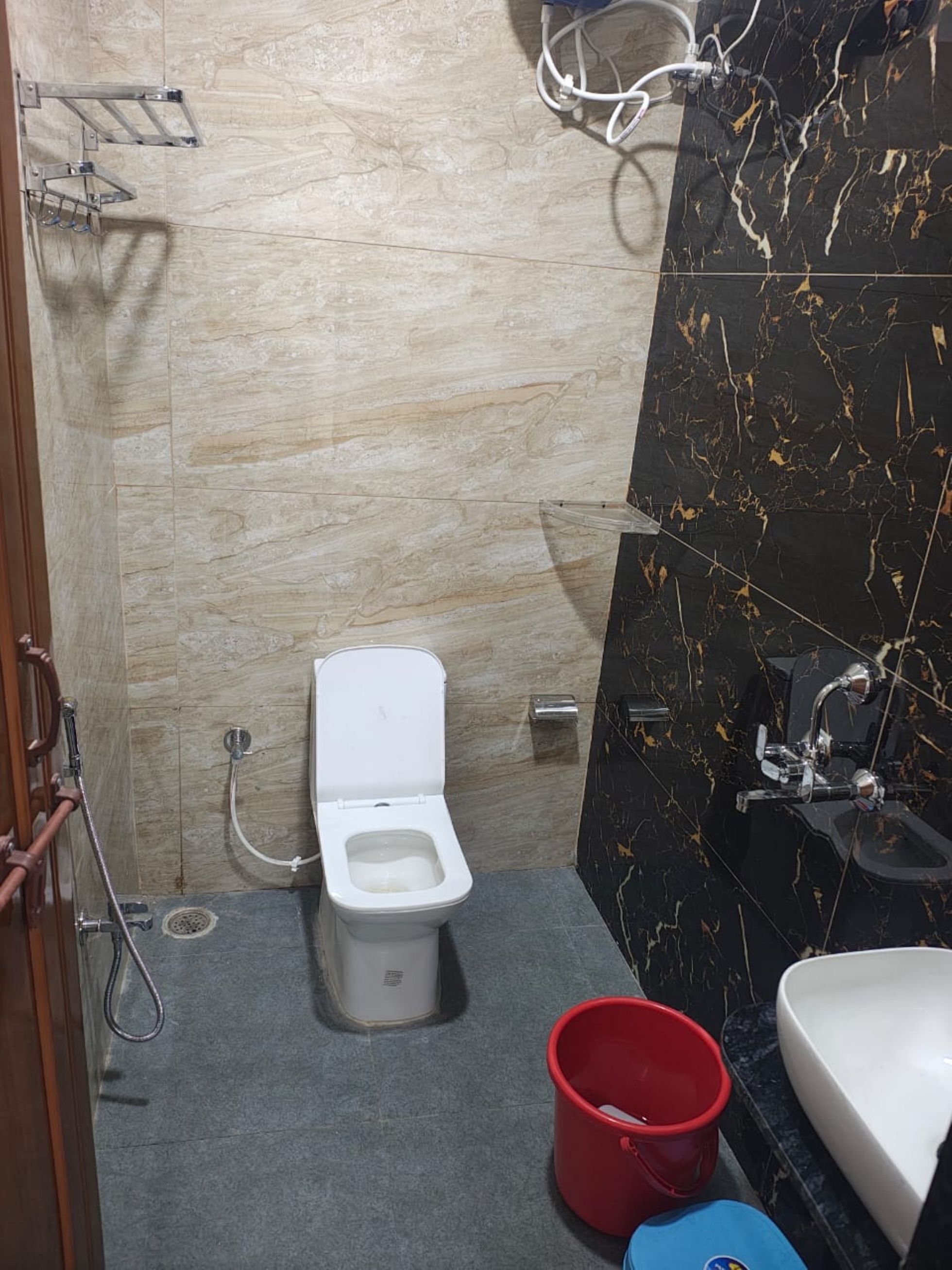 A bathroom with a toilet, a sink, and a shower area.
