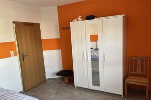 A room with a wardrobe, a bench, and a chair. - Holiday apartment with 2 bedrooms (Werdum)