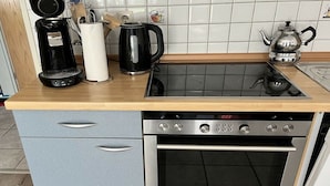 Cuina amb forn integrat, cafetera, batedora i torradora a la superfície.