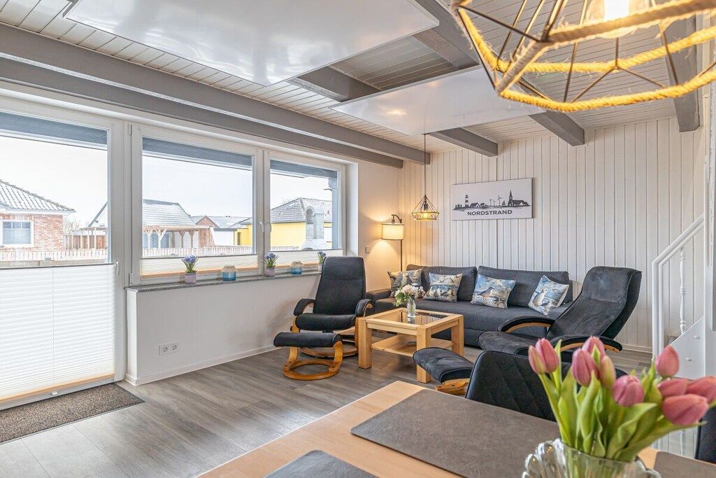 Un salon moderne avec un canapé, des fauteuils, une table basse et une vue sur la ville.