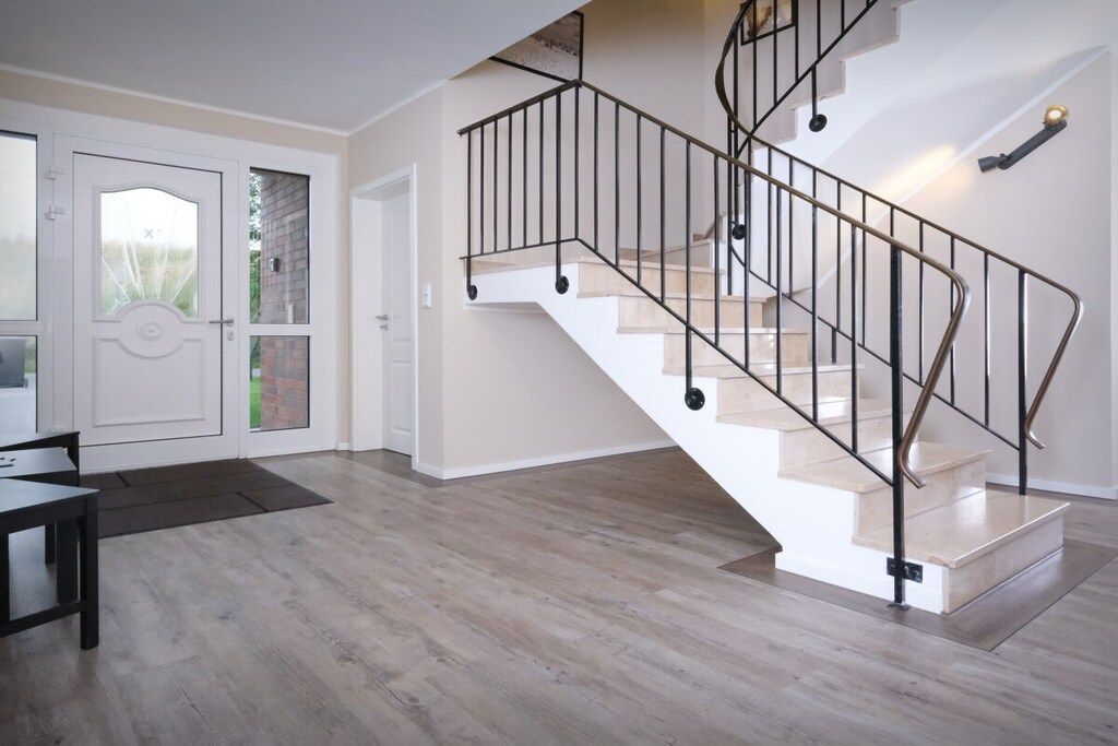Un intérieur moderne avec un escalier en colimaçon, un plancher en bois et un coin repas.