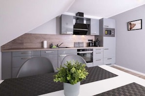 Een moderne keuken met grijze kastjes, een houten aanrechtblad en een magnetron.