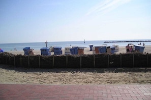 A beach with numbered beach huts and a wooden fence. - Baltic Sea View Damp (Damp)