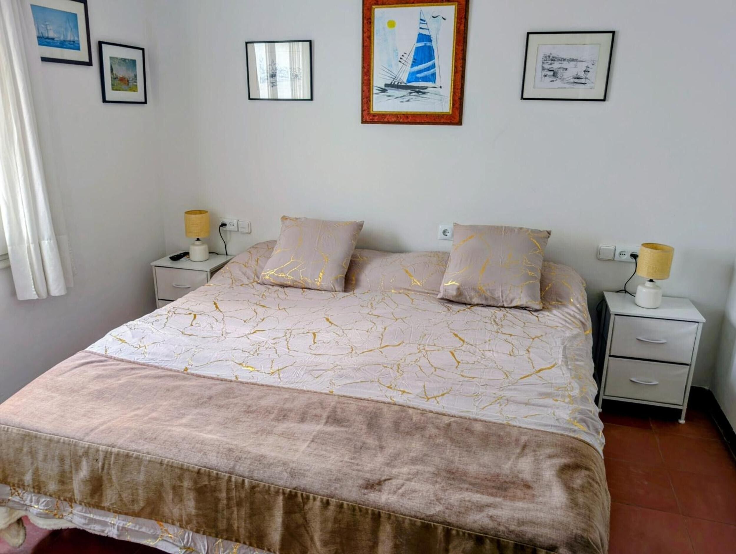 Een slaapkamer met een bed, twee nachtkastjes en een bedbank.