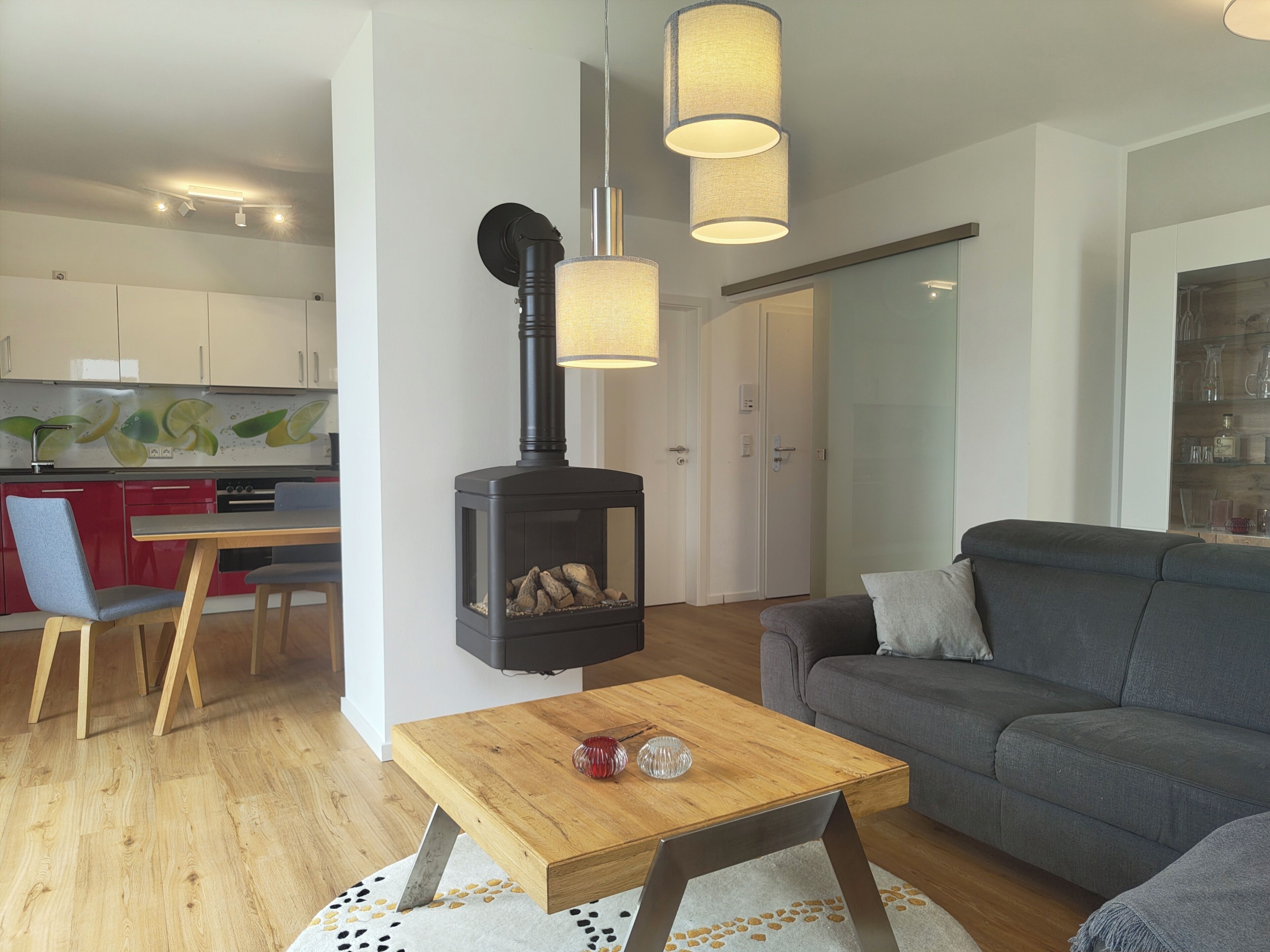 A modern living room with a sofa, a wooden coffee table, and a fireplace.