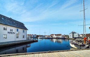 Ein Yachthafen mit vertäuten Booten, ein weißes Gebäude mit der Aufschrift 'HAVN' auf der linken Seite und ein Holzsteg im Vordergrund.