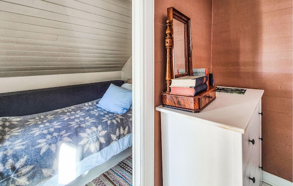 A bedroom with a bed, a dresser, and a mirror.