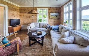 A cozy living room with a sofa set, a coffee table, and a television.