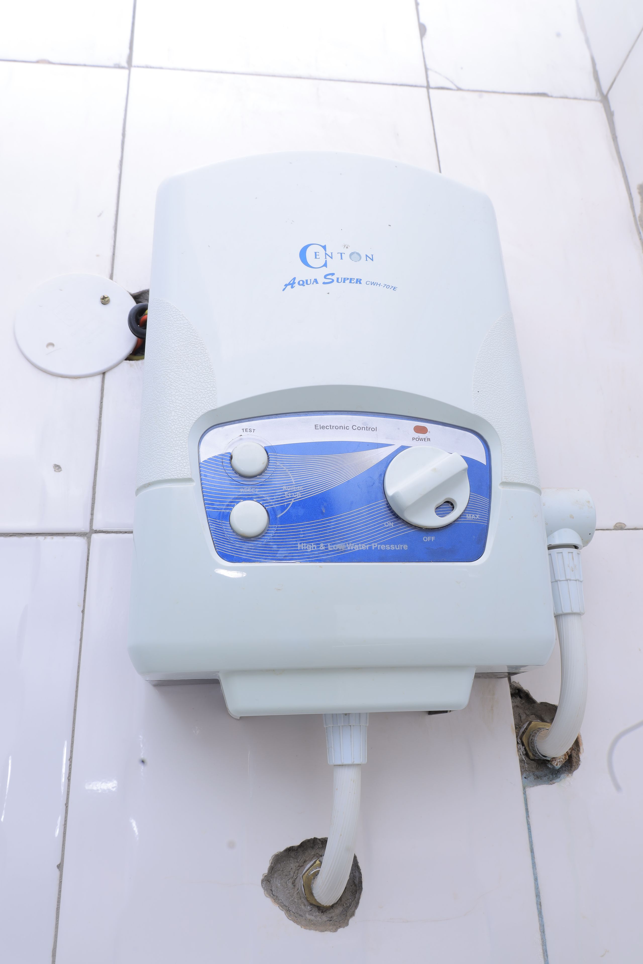 A water heater with a control panel, a power outlet, and a drain.