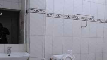 Casa de banho com sanita, lavatório e espelho.