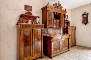 Ein Zimmer mit zwei großen Holzkombinationen, einer Wanduhr und einem gerahmten Bild über den Schränken.