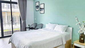 Une chambre à coucher avec un lit, une table de chevet, une chaise et une vue sur un balcon.