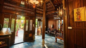 A wooden interior with a high ceiling, chandeliers, and a sign indicating a room type. - Thien Y Villas (Phu Xuan)