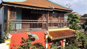 A traditional building with a balcony, a decorative ceiling, and a colorful facade. - Thien Y Villas (Phu Xuan)