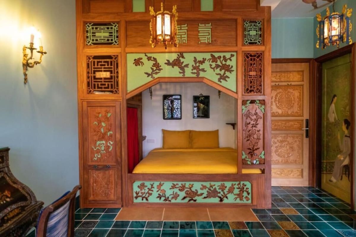 Ein traditionell eingerichtetes Zimmer mit einem Bett, dekorativen Holzvertäfelungen und einem Fliesenboden.